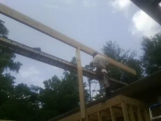 Carpenter setting a ridge beam over a new addition frame — Ice Dam Removal by Roofing Brothers in Verona Beach