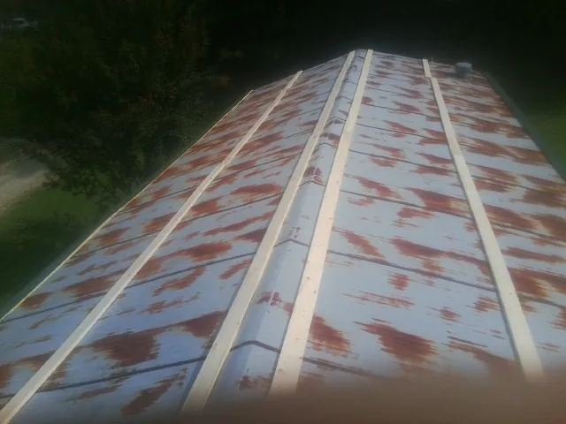 Rusted metal roof panels with new wood purlins before replacement — Storm Damage Roof Repair in Verona Beach by Roofing Brothers