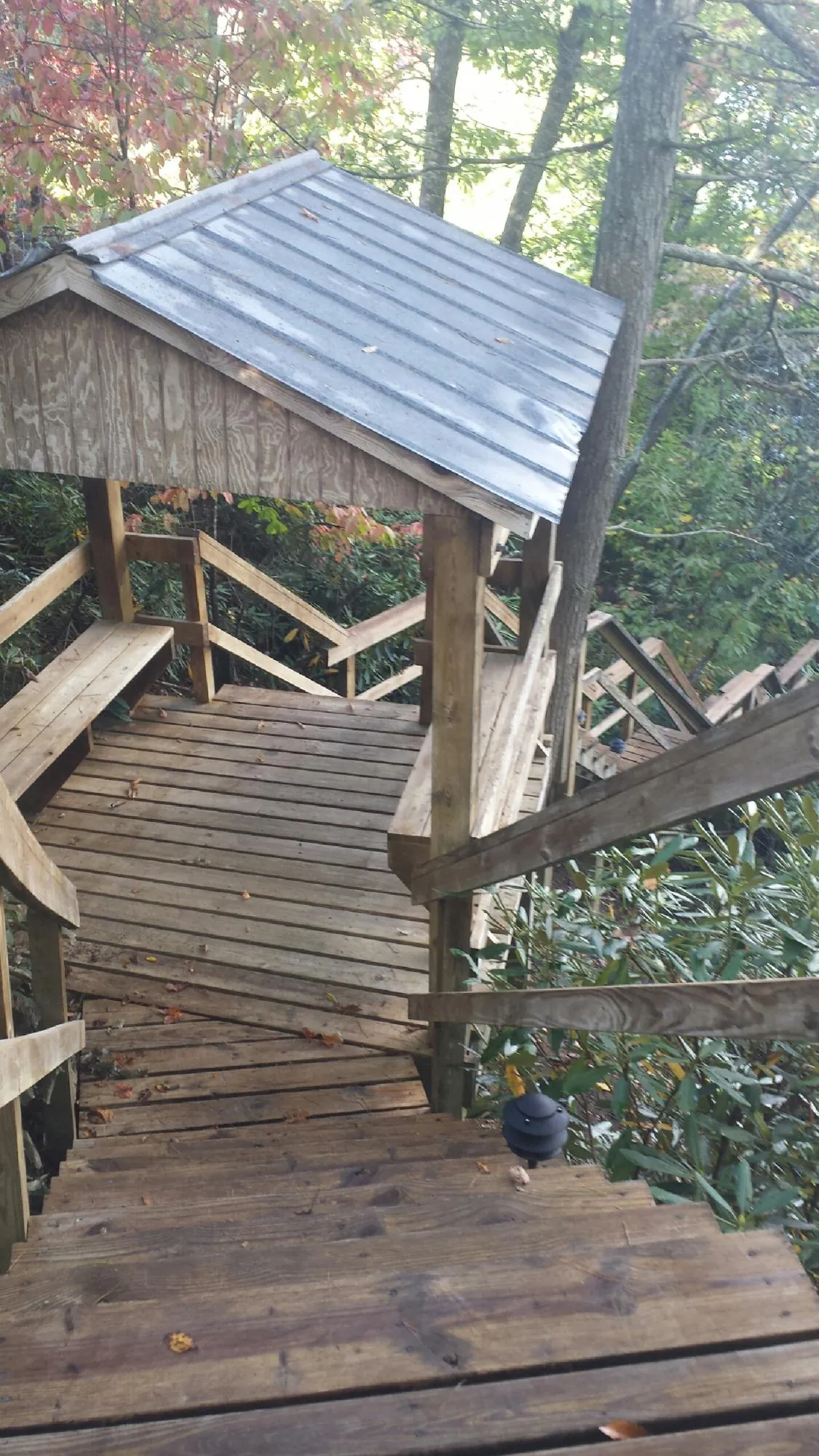 Metal roofed shelter over wooden steps on a wooded walkway — Skylight Repair & Installation work by our crew in Verona Beach