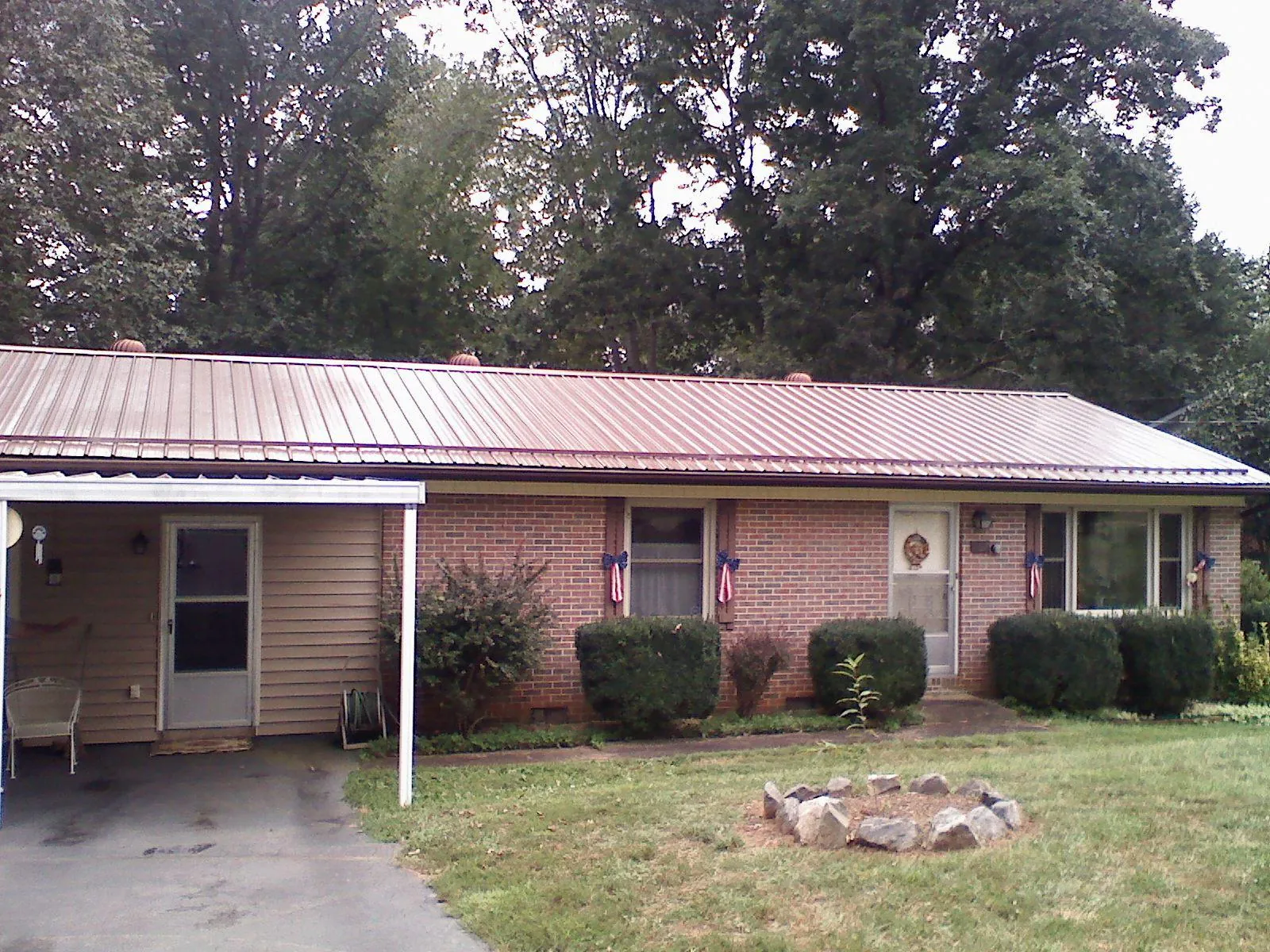 Bronze metal roof and carport on a brick ranch home — Roof Repair work by our crew in Verona Beach